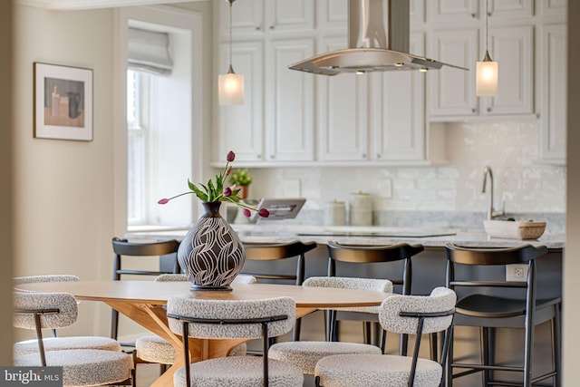 kitchen with a healthy amount of sunlight, white cabinetry, and exhaust hood