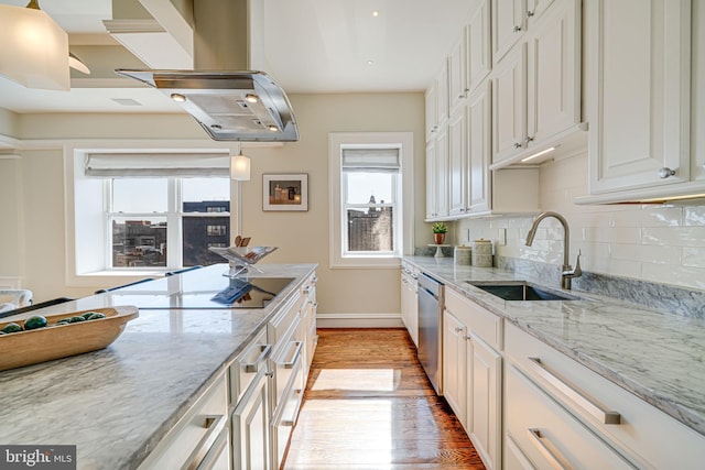 kitchen with a sink, light wood-style floors, backsplash, dishwasher, and island exhaust hood