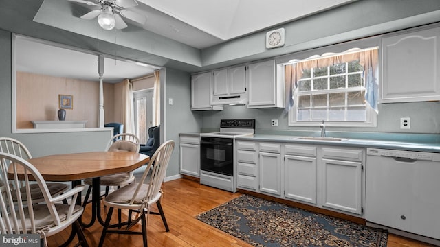 kitchen with electric stove, light countertops, white dishwasher, and a sink