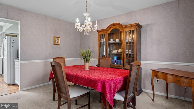 dining area featuring a notable chandelier and light colored carpet