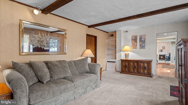 living room with a warm lit fireplace, visible vents, beam ceiling, and light colored carpet