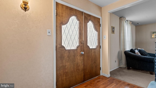 foyer with baseboards, wood finished floors, and french doors