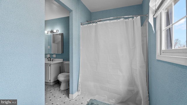 full bathroom with a textured wall, toilet, a shower with curtain, tile patterned floors, and vanity