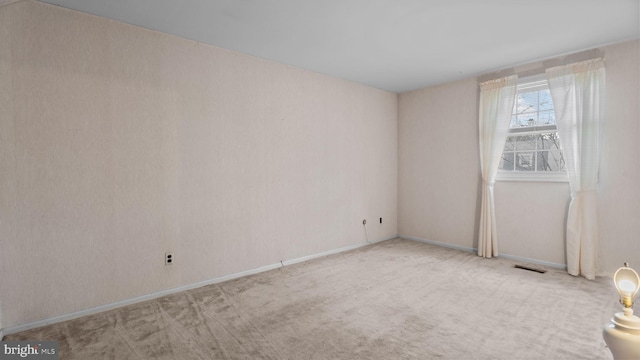 unfurnished room featuring visible vents and light colored carpet