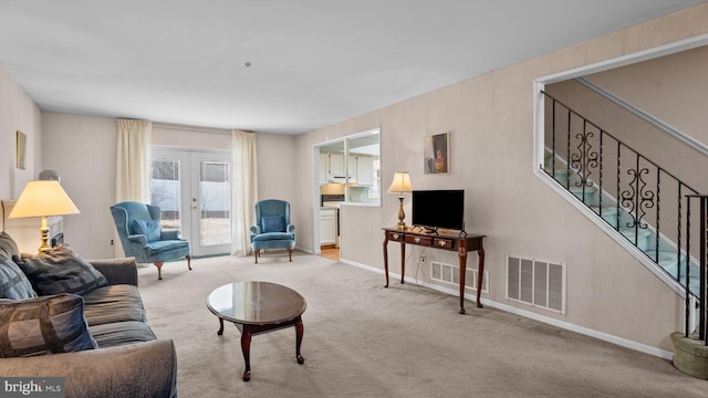 living room featuring light carpet, stairway, visible vents, and french doors