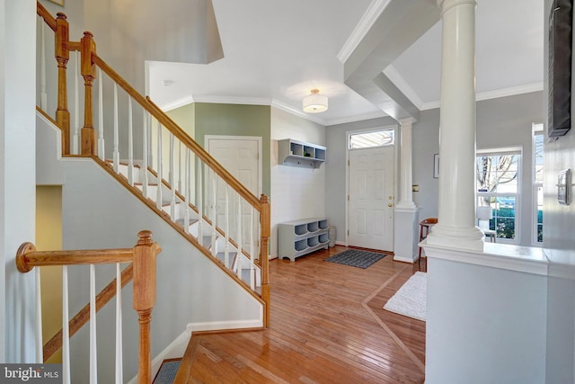 foyer with a wealth of natural light, wood finished floors, and decorative columns