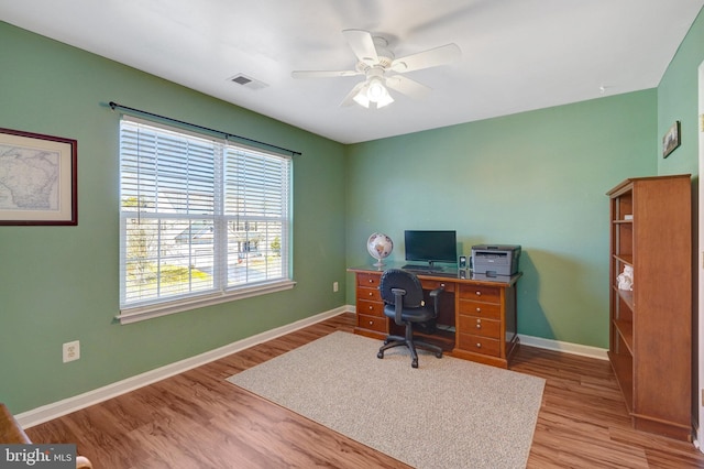 office area featuring a ceiling fan, visible vents, light wood-style flooring, and baseboards