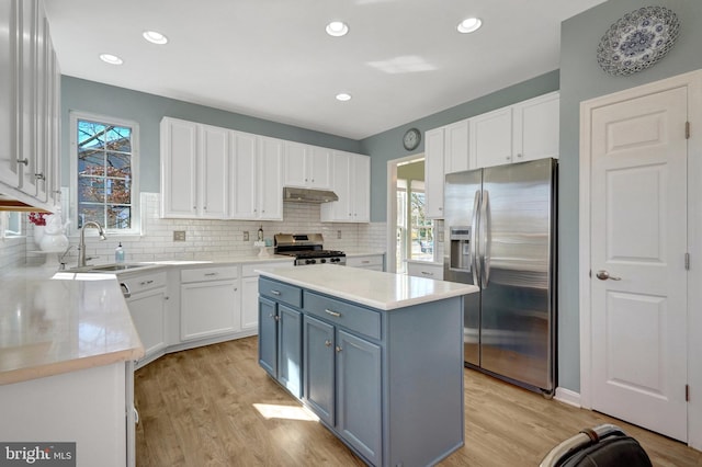 kitchen with under cabinet range hood, white cabinetry, stainless steel appliances, and light countertops