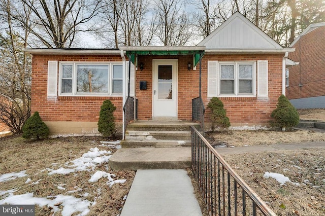 bungalow-style home featuring brick siding and fence