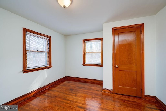 unfurnished room with baseboards and wood finished floors