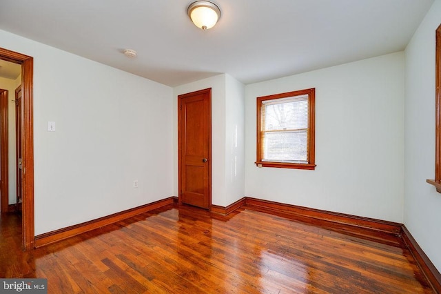 unfurnished room featuring baseboards and hardwood / wood-style floors