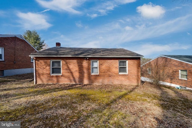 view of property exterior featuring a chimney and brick siding