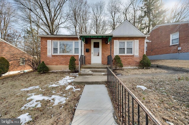 view of front of house featuring brick siding and fence