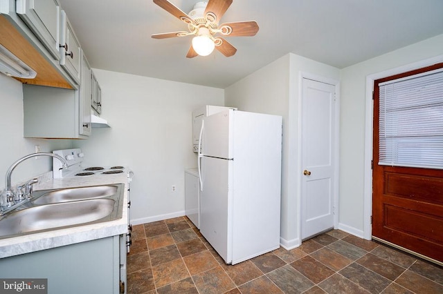 kitchen with white appliances, baseboards, light countertops, and a sink