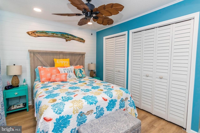 bedroom with a ceiling fan, light wood-style flooring, ornamental molding, multiple closets, and recessed lighting