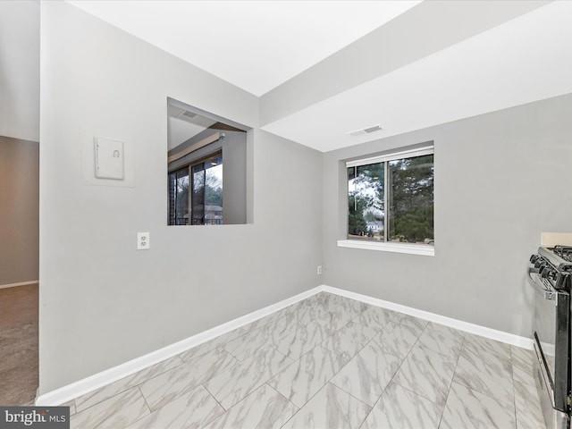 empty room with marble finish floor, visible vents, and baseboards