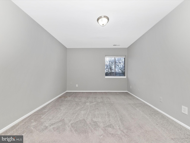 carpeted empty room featuring visible vents and baseboards