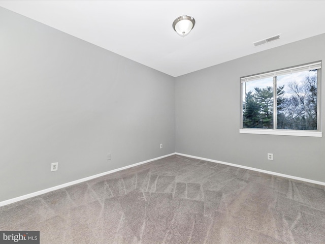 carpeted spare room featuring baseboards and visible vents