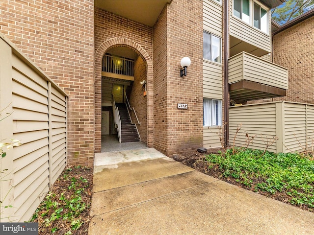 property entrance featuring a balcony and brick siding