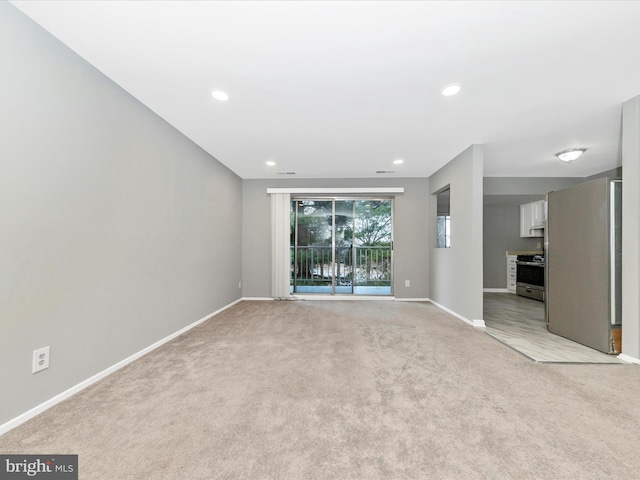 spare room featuring recessed lighting, baseboards, and light colored carpet