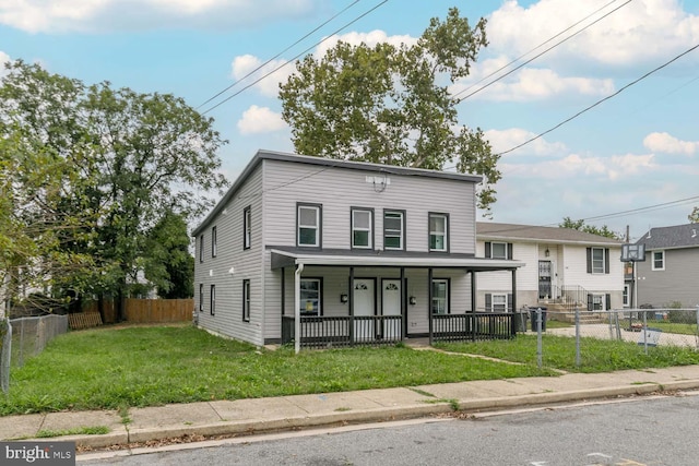 view of front facade with a porch, a fenced front yard, and a front yard