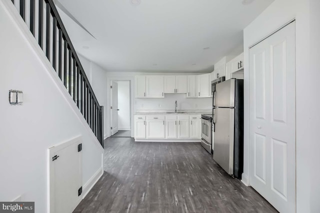 kitchen featuring dark wood finished floors, appliances with stainless steel finishes, white cabinets, and light countertops