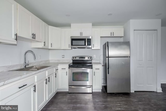 kitchen with stainless steel appliances, a sink, and white cabinets