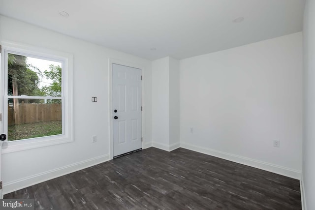 unfurnished room featuring dark wood-type flooring and baseboards