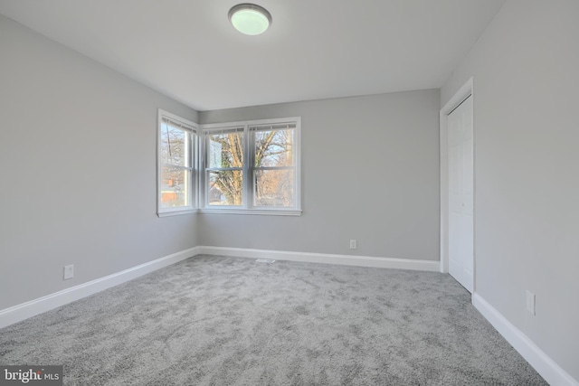 empty room with carpet and baseboards