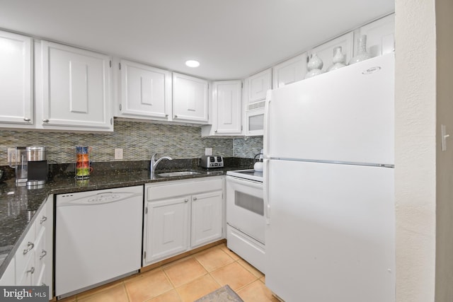 kitchen featuring white appliances, white cabinetry, a sink, and light tile patterned floors