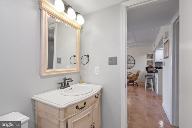 half bath with tile patterned flooring, vanity, and toilet