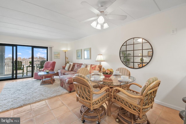 tiled dining room featuring a ceiling fan and baseboards