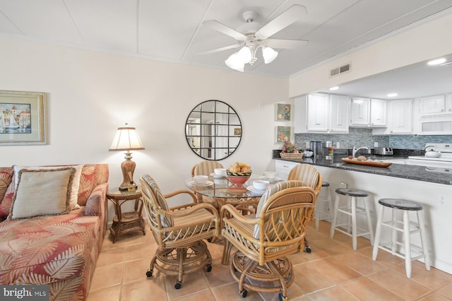 dining room with ornamental molding, visible vents, ceiling fan, and light tile patterned floors