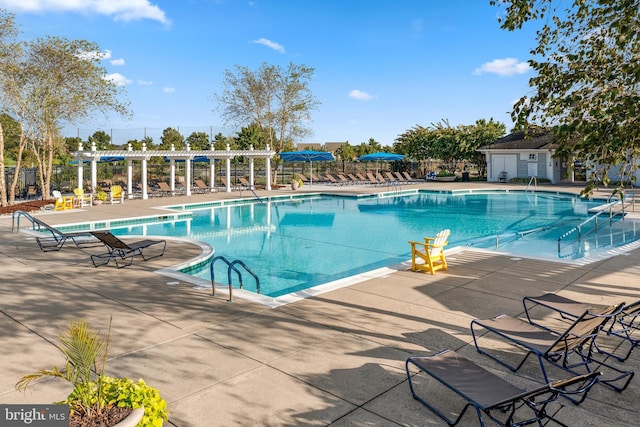 pool with a patio area, fence, and a pergola