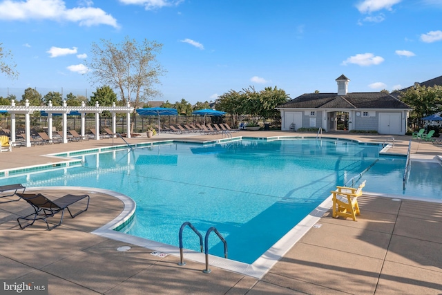 community pool with a patio area and a pergola