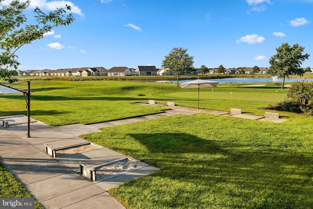 surrounding community featuring a yard, a water view, a residential view, and view of golf course