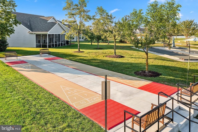 view of property's community featuring a yard and shuffleboard