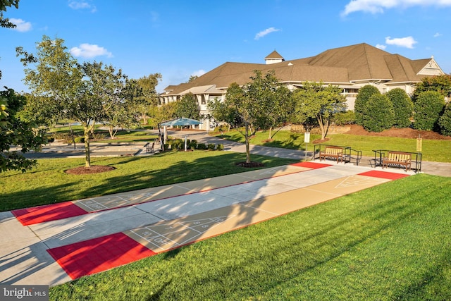 view of community with shuffleboard and a lawn