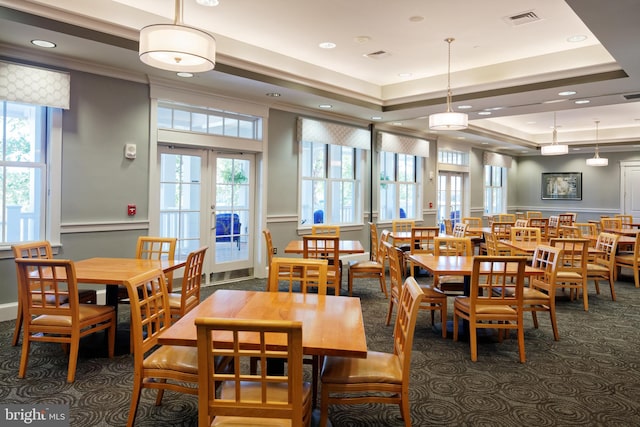 dining space with a tray ceiling, french doors, a healthy amount of sunlight, and visible vents