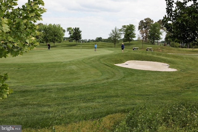 surrounding community featuring view of golf course and a lawn