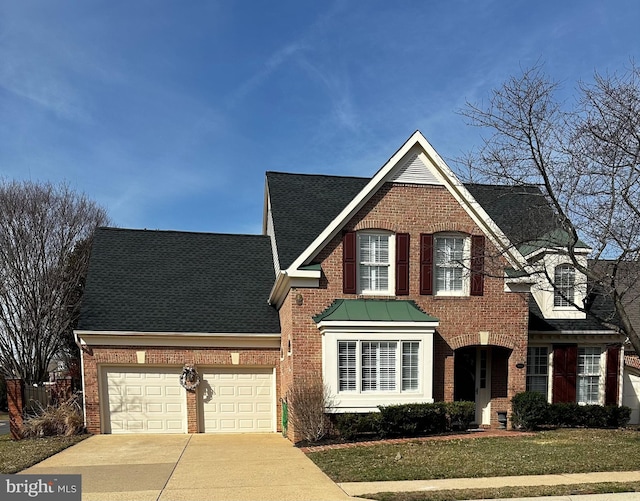 traditional-style house with brick siding, concrete driveway, a garage, and roof with shingles