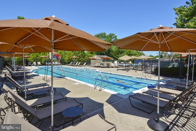 pool with a patio area and fence