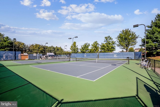 view of tennis court with fence and community basketball court