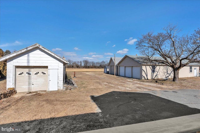 view of yard with a garage and an outbuilding