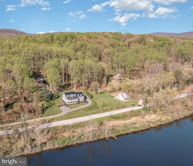 drone / aerial view featuring a water view and a forest view