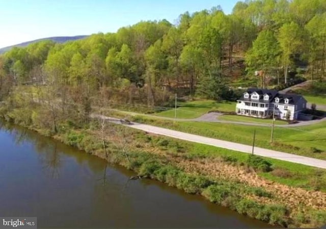 view of community with a water view, a yard, and a wooded view