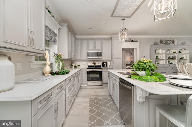 kitchen featuring a sink, a kitchen island, appliances with stainless steel finishes, a kitchen bar, and pendant lighting