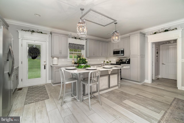 kitchen featuring stainless steel appliances, light countertops, decorative light fixtures, and gray cabinetry