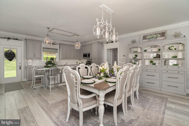 dining room featuring light wood finished floors and ornamental molding