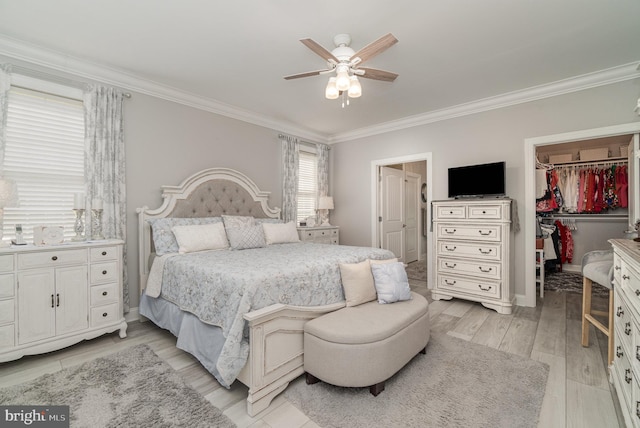 bedroom with ornamental molding, a walk in closet, light wood-type flooring, and a closet